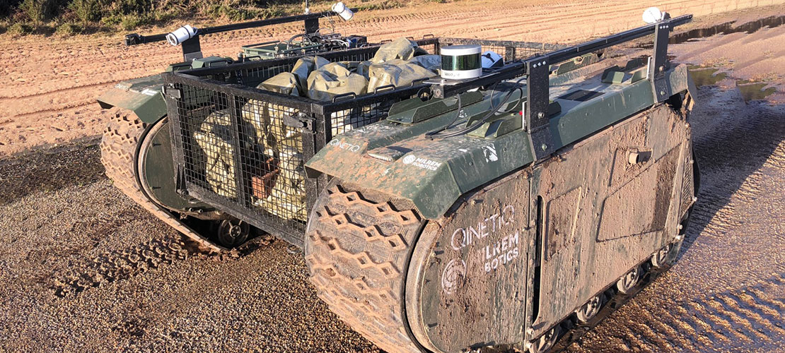 TITAN autonomous ground vehicle pictured dirty with cargo loaded at muddy testing ground