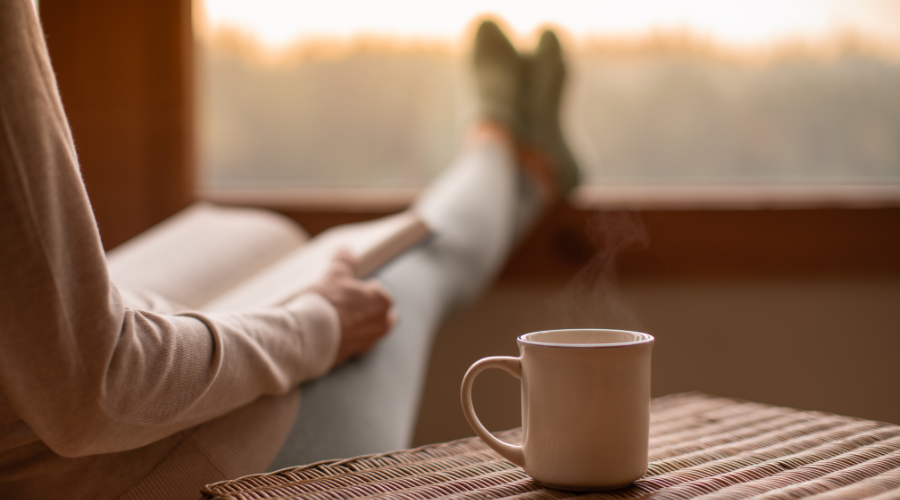 A relaxed person reading with a cup of tea