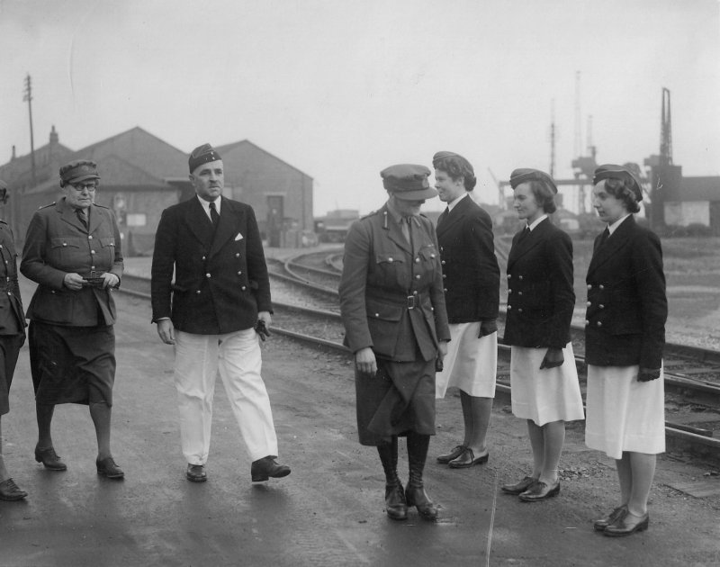 16 December 1940. Visit by Dame Helen Gwynne-Vaughan (Commander ATS). Colonel Lickman (Superintendent), Dame Helen, Company Asistants J Honeyburne, K Warwick and J Bathurst. RA Workshops and Gantry Battery at rear (P&EE)